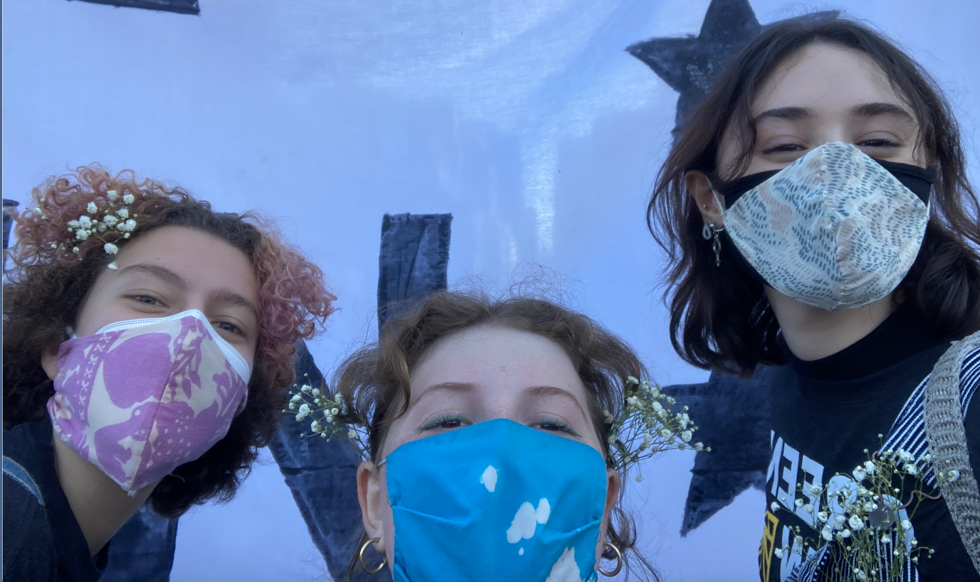 Three PCR women in face masks at a climate justice rally